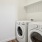 a white laundry room with a white door and a white wall