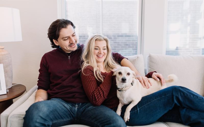 a man and a woman sitting on a couch with a dog